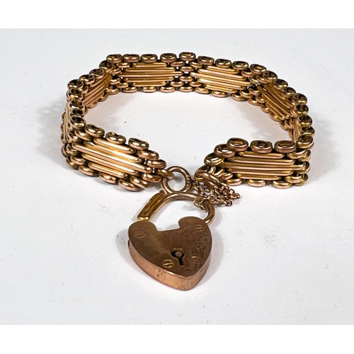 715A - A yellow metal gate bracelet st. 9ct with 9ct hallmarked gold heart locket, 19.8gm