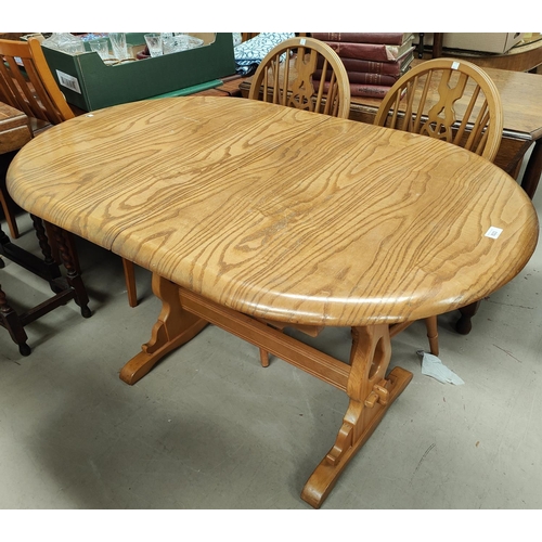 823 - An Ercol style dining suite comprising oval extending table and 6 (4 + 2) wheel back chairs