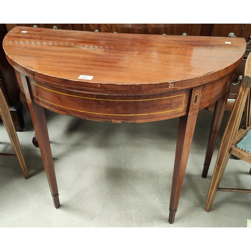 824 - A Sheraton style inlaid mahogany card table, the demi-lune fold over top with baize lining, on squar... 