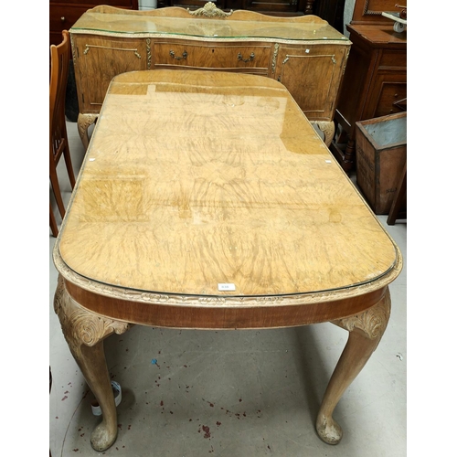 838 - A burr walnut dining table in the Epstein manner with rounded rectangular edges, carved lip and cabr... 