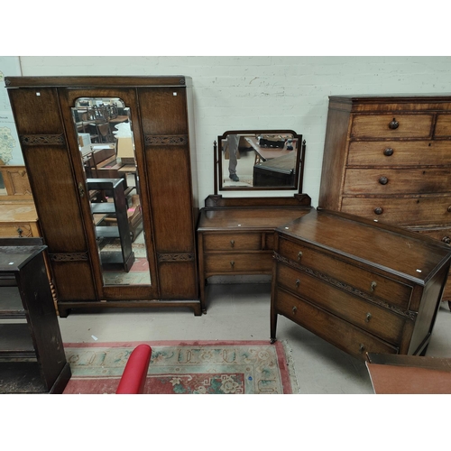 854 - An Oak Arts and Crafts style three piece bedroom suite with mirror door wardrobe, dressing chest and... 