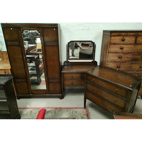 854 - An Oak Arts and Crafts style three piece bedroom suite with mirror door wardrobe, dressing chest and... 