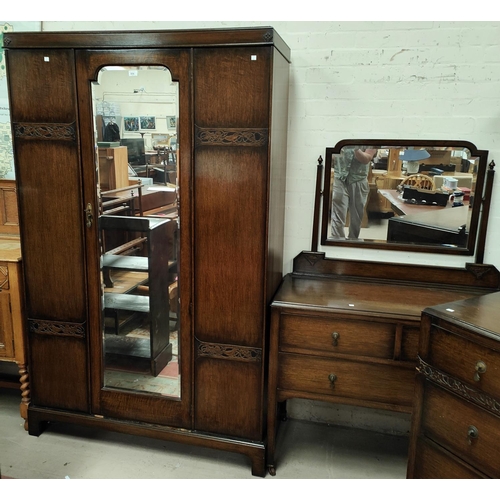 854 - An Oak Arts and Crafts style three piece bedroom suite with mirror door wardrobe, dressing chest and... 