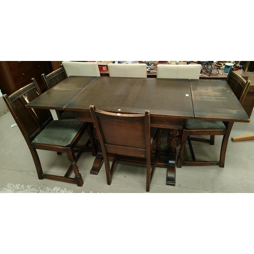 858 - A 1930's oak dining suite in the Jacobean style comprising draw leaf table on carved bulbous legs an... 