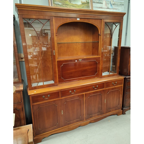 862 - A Regency style reproduction yew wood side cabinet, full height with twin glazed cupboards and fall ... 