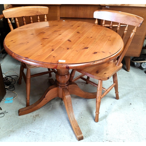 863 - A modern pine breakfast suite comprising circular table and 4 spindle back chairs