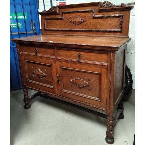 877 - A 1930's beaded oak sideboard with low raised back, 2 drawers and double cupboard