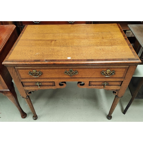 916 - An 18th century crossbanded oak lowboy with frieze drawers, 2 small drawers and shaped apron, on clu... 