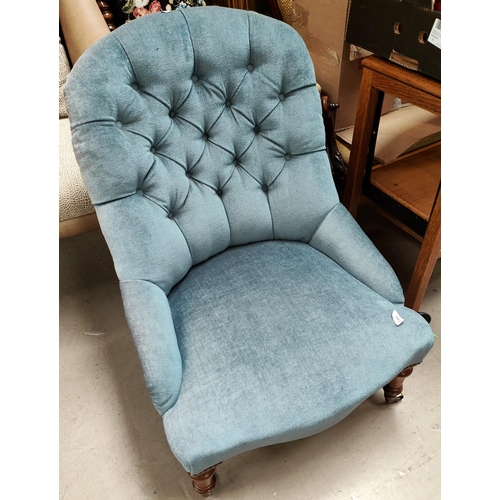 918 - A Victorian spoon back armchair on turned legs and castors, in deeply buttoned turquoise fabric