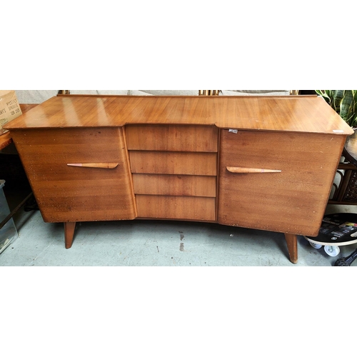 926 - A mid 20th century light wood sideboard with angled and stepped front, four central drawers and two ... 