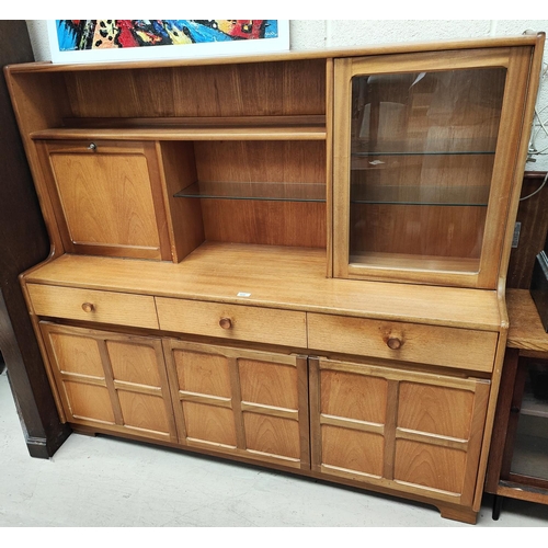 928 - A mid 20th century high back teak side board cupboards and drawers bellow with fall front cocktail s... 