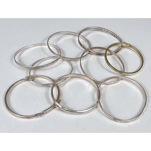 745 - Nine white metal bangles stamped 925, some with cut and etched decoration, gross 80gms.