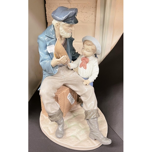 591 - A Lladro group:  old sailor giving a child a boat, height 27cm