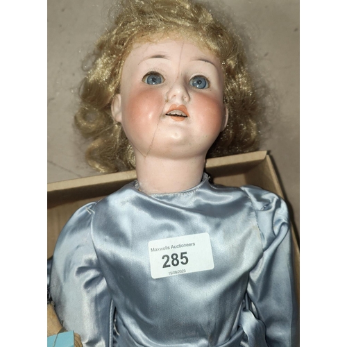 285 - A late 19th/early 20th century bisque head girl doll (head cracked), in blue satin dress, length 51c... 