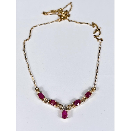 746 - A yellow metal necklace stamped '375' set with diamonds and rubies in 'V' formation, 4.5gm