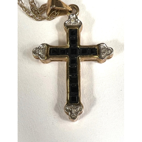 746A - A cross pendant set with small diamonds and square cut sapphires on fine chain stamped '375', 2.2gm