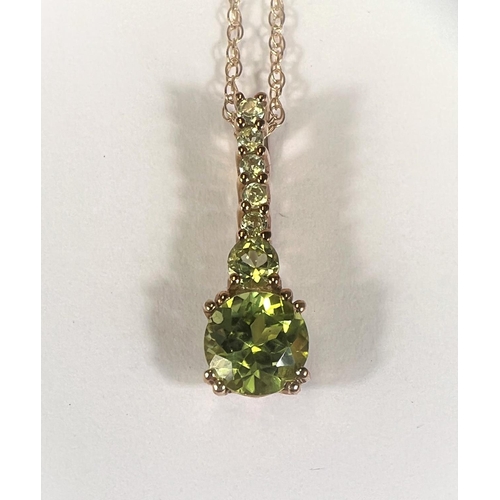 746E - An elongated peridot pendant stamped '375', on fine chain stamped '375', 1.8gm