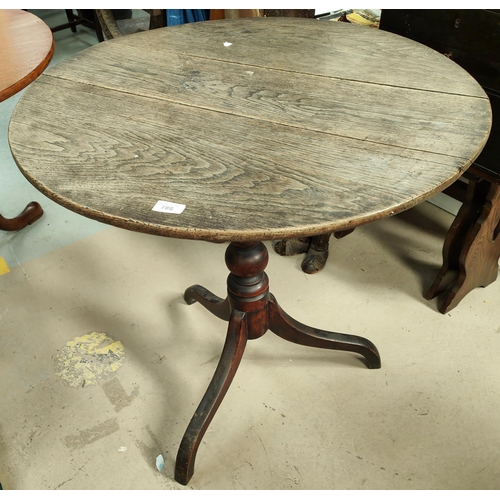 786 - A 19th century oak tilt top circular table with turned column and tripod feet