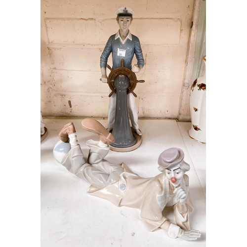 594 - A Lladro figure:  young sailor at the wheel; another:  reclining clown with ball, 38cm