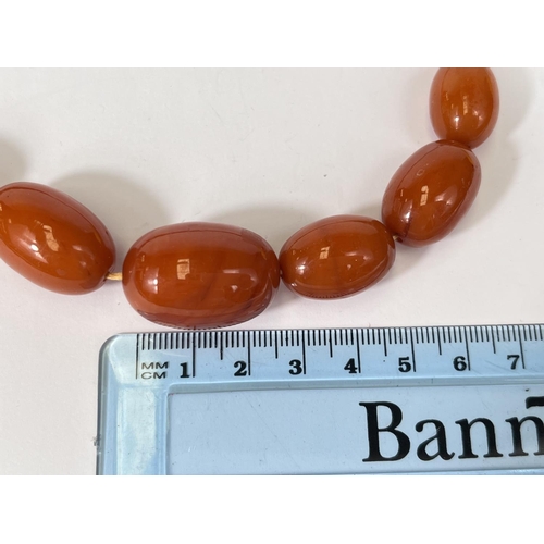 740 - A vintage Amber coloured Bakelite necklace, graduating beads, internal swirl, largest bead 2.5cm, we... 