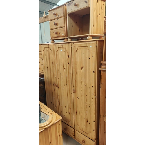 821 - A modern pine triple wardrobe, kneehole dressing table and pair of bedside cabinets