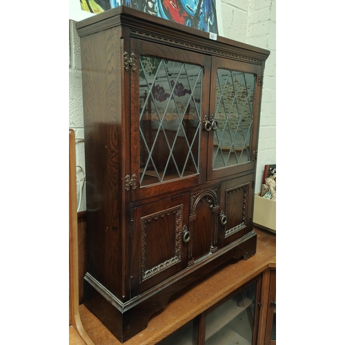 930 - An oak side cabinet with leaded glass double doors 