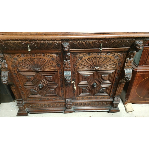 1019 - A Victorian Gothic extensively carved oak buffet sideboard with shell icons, head and paws carving w... 