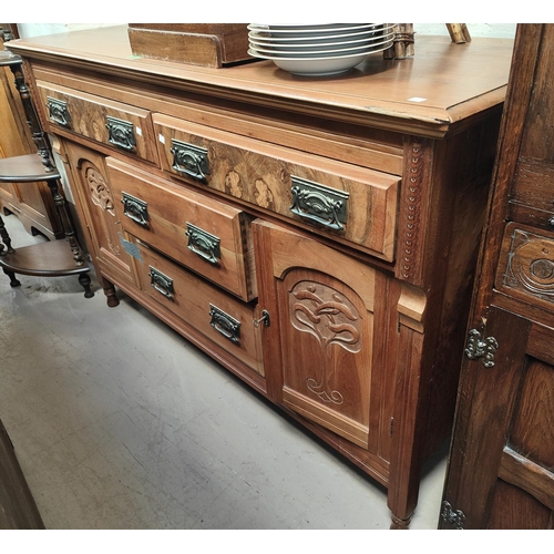 1059 - An Edwardian sideboard in stripped and refinished figured walnut, with 4 drawers and twin side cupbo... 