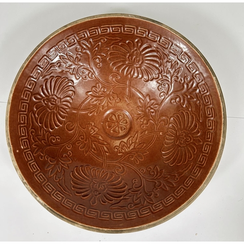 421 - A Chinese Ox-blood coloured bowl with embossed decoration of flowers, dia. 22cm