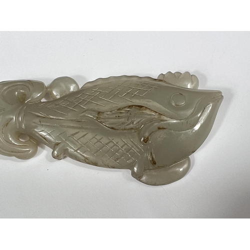 432 - A Chinese jade coloured hardstone carving of a fish on associated stand, length 9cm