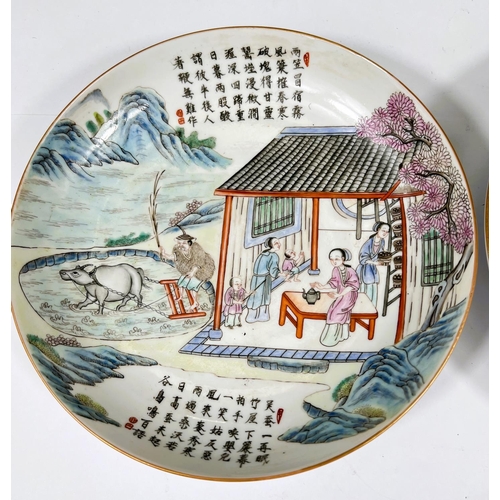 445 - A pair of Chinese dishes with domestic scenes in polychrome text above and below, with marks to base... 