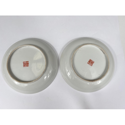 445 - A pair of Chinese dishes with domestic scenes in polychrome text above and below, with marks to base... 