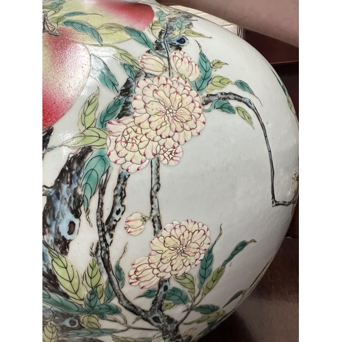 455 - A very large Chinese bottle vase decorated with polychrome peaches and flowers on branches with seal... 