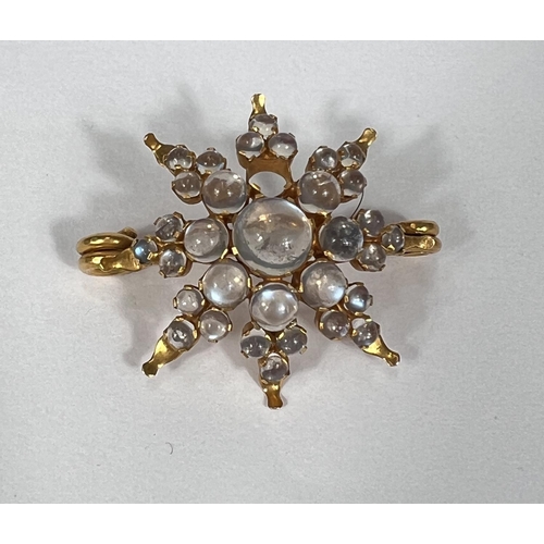 661 - A yellow metal star brooch set graduated moonstones, stamped '9ct', 5.7gm (1 stone missing)