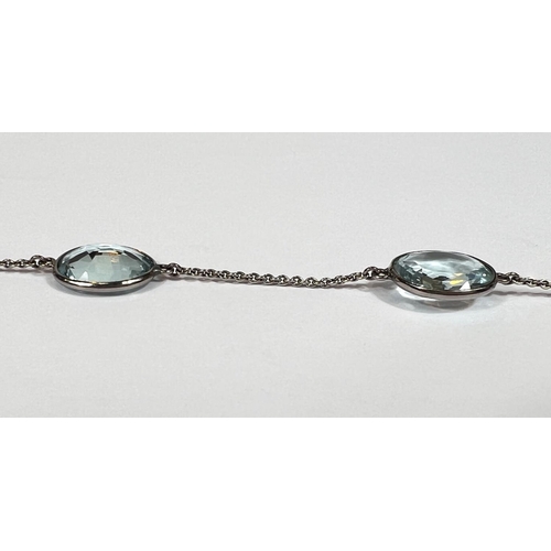 666 - An Art Deco white gold spectacle chain necklace, stamped '18ct' with 22 graduating aquamarine  stone... 