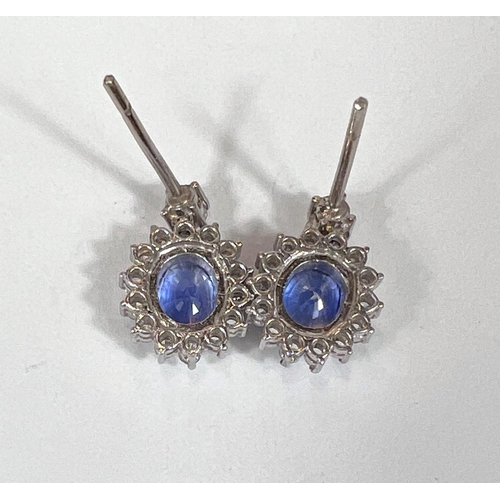 669 - A pair of sapphire and diamond earrings, large sapphire central stones surrounded by diamonds 18k