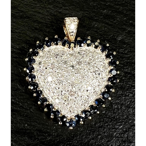 670 - A 14k yellow and white gold heart shaped pendant encrusted with diamonds surrounded by sapphires