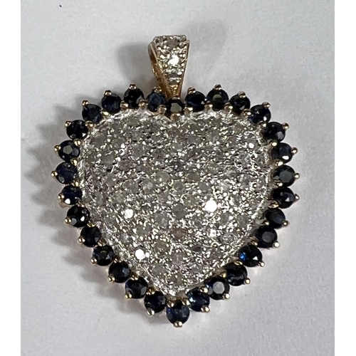 670 - A 14k yellow and white gold heart shaped pendant encrusted with diamonds surrounded by sapphires