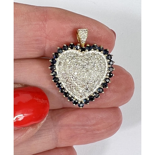 670 - A 14k yellow and white gold heart shaped pendant encrusted with diamonds surrounded by sapphires