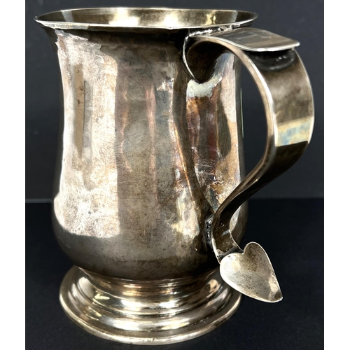 673 - A hallmarked silver baluster pint mug, monogrammed, with 'S' scroll handle, on circular foot, London... 