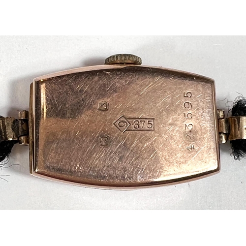 712 - A 1930's 9 carat hallmarked gold wristwatch of rounded rectangular form, on black fibre strap, gross... 