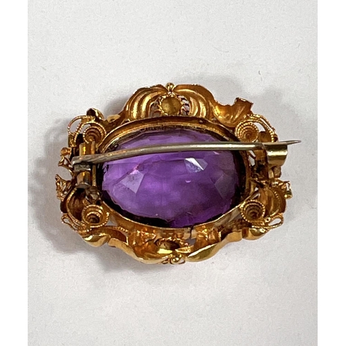 713 - A 9 carat hallmarked gold Victorian brooch with large amethyst in ornate scroll and acanthus gilt me... 