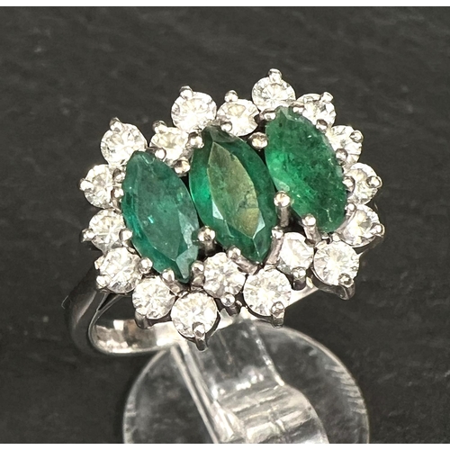 745 - A ladies dress ring set 3 marquise cut emeralds surrounded by 18 diamonds in 18 carat white gold