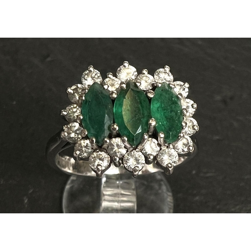 745 - A ladies dress ring set 3 marquise cut emeralds surrounded by 18 diamonds in 18 carat white gold