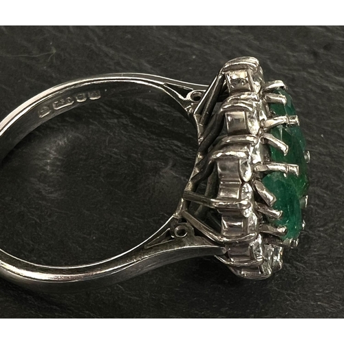 745 - A ladies dress ring set 3 marquise cut emeralds surrounded by 18 diamonds in 18 carat white gold