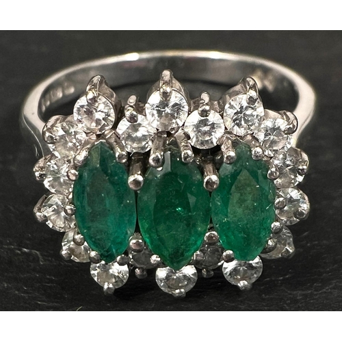 745 - A ladies dress ring set 3 marquise cut emeralds surrounded by 18 diamonds in 18 carat white gold