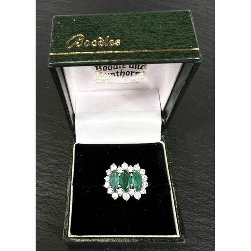 745 - A ladies dress ring set 3 marquise cut emeralds surrounded by 18 diamonds in 18 carat white gold