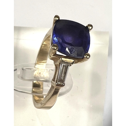 750 - A modern ladies dress ring set square cut tanzanite with diamond baton to each shoulder, the yellow ... 