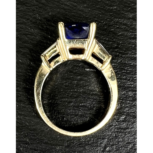 750 - A modern ladies dress ring set square cut tanzanite with diamond baton to each shoulder, the yellow ... 