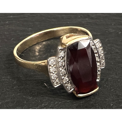 753 - An Art Deco style dress ring set garnet surrounded by 18 small diamonds, 18 carat yellow gold shank,... 